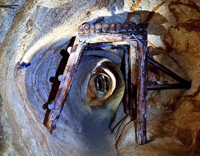 Holzgestützter Stollen im Inneren eines historischen Bergwerks.