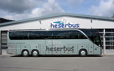 Reisebus „Heserbus“ vor Betriebshof geparkt.