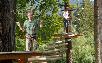 Besucher im Hochseilgarten zwischen Plattformen