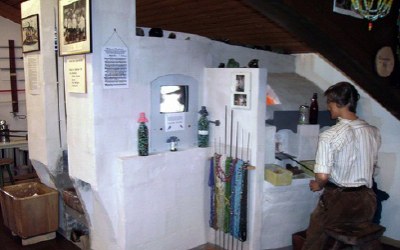 Innenraum des Glasmuseums Warmensteinach mit historischen Glasöfen und Exponaten.