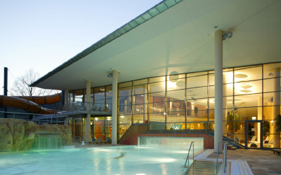 Außenbecken der Therme Obernsees bei Mistelgau mit moderner Glasarchitektur in der Abenddämmerung.
