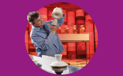 Mann begutachtet Porzellan in einer Ausstellung im Porzellanikon Selb.