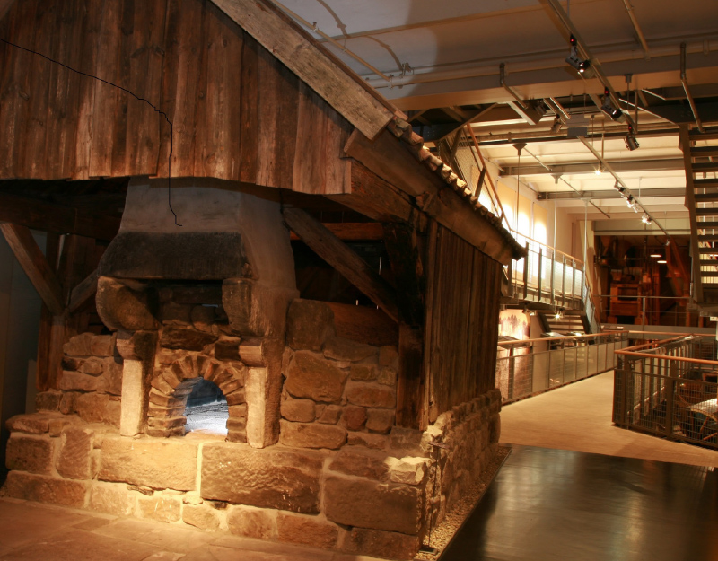 Historische Backstube im Kulmbacher Brotmuseum mit Steinofen und traditionellen Arbeitsgeräten.