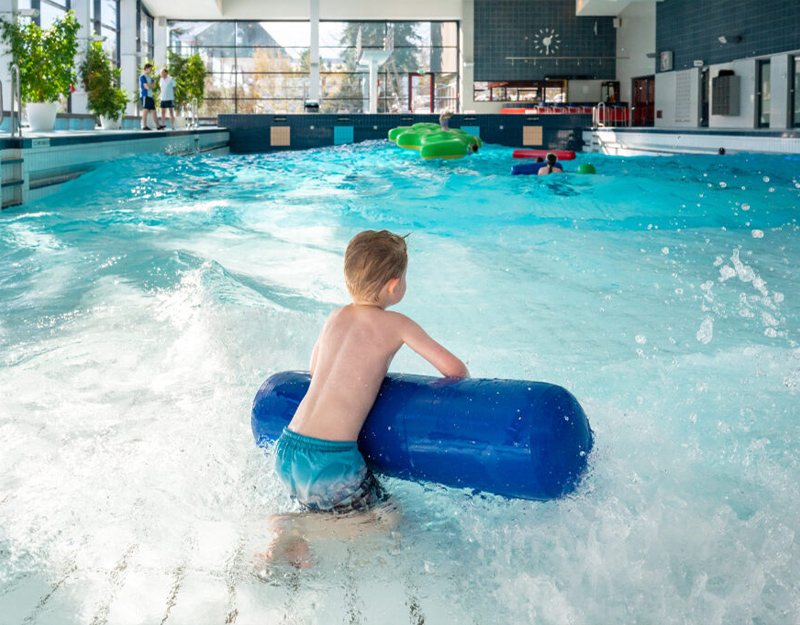 Freizeitbad Aquawell Helmbrechts mit Wellenbecken und Badegästen.