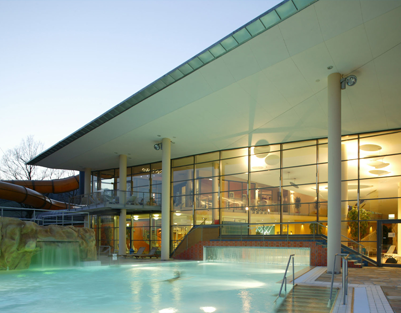 Therme Obernsees mit Außenbecken und moderner Glasarchitektur.