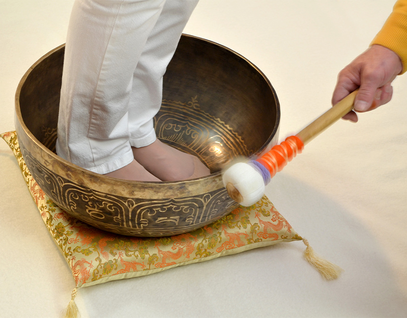 Fußmassage mit Klangschale und Schlägel.