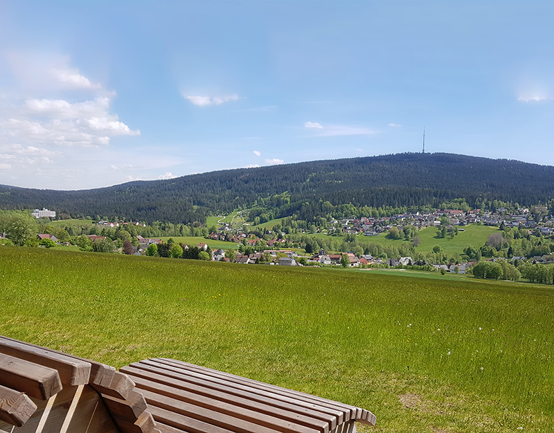 Panoramaausblick über Bischofsgrün und den Ochsenkopf von einer Relaxliege im Freien.