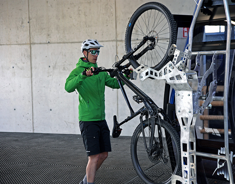 Mountainbiker hängt sein Fahrrad in die Halterung der Seilbahnstation am Ochsenkopf.