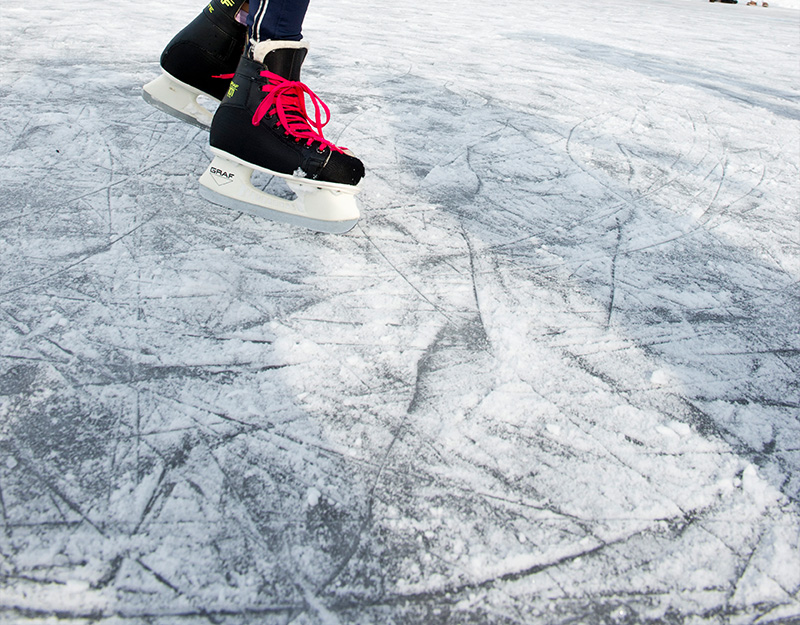 Schlittschuhläufer auf Eisfläche im Winter