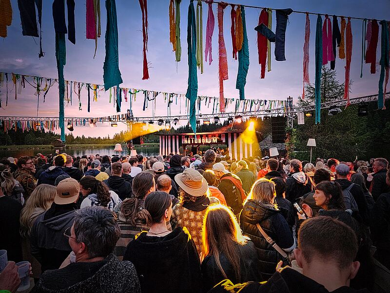 Junge Menschen tanzen ausgelassen beim Naturraum Open Air am Fichtelsee.